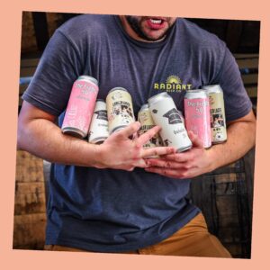 A young man holds a variety of private label cans in his arms